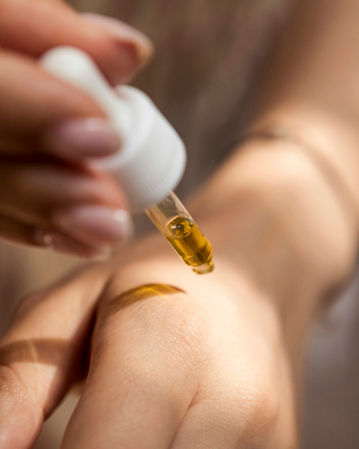 Compte-gouttes de sérum ambré sur la peau